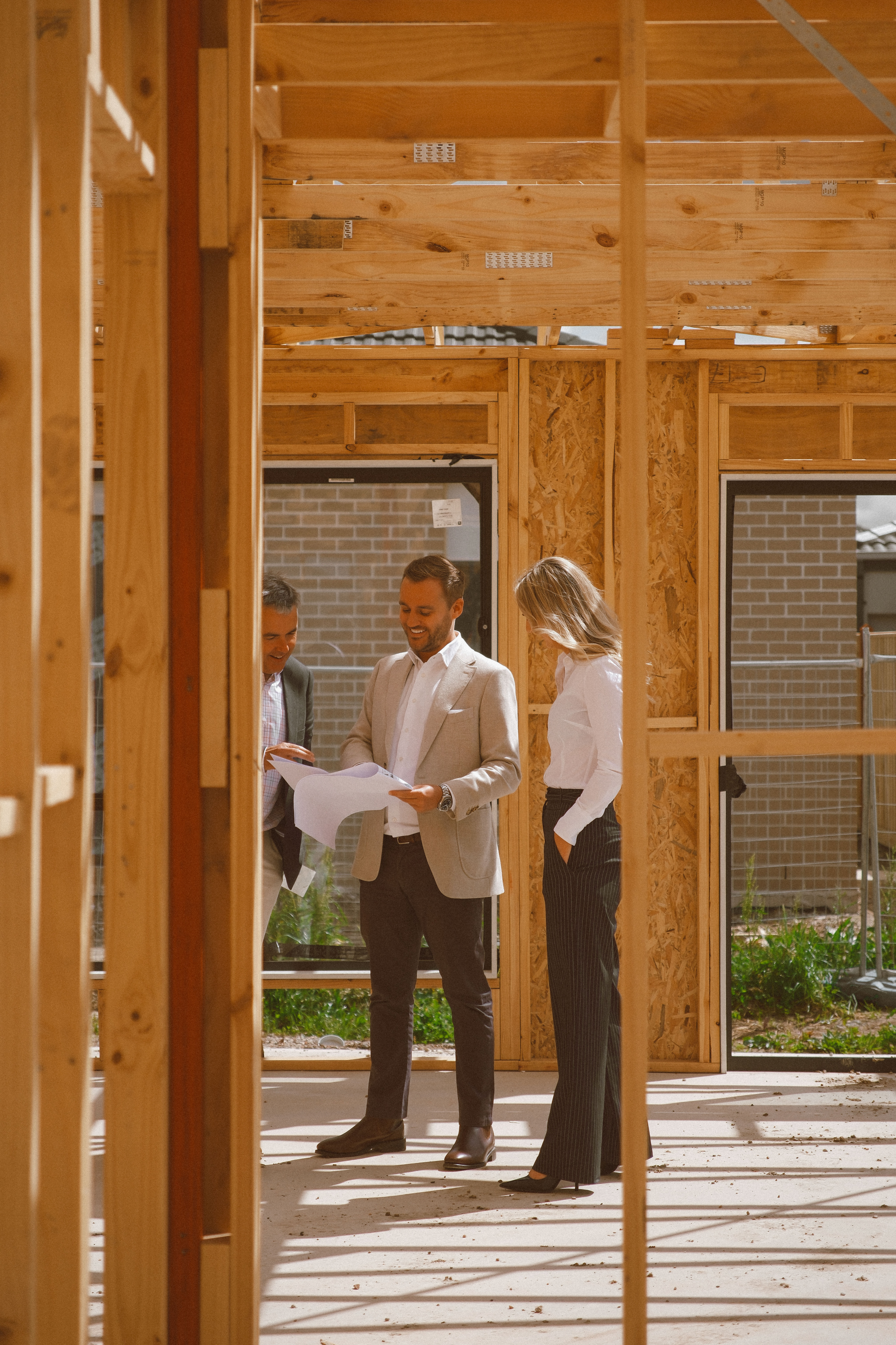 Turnkey advisors on site with a client inside a timber-framed home under construction